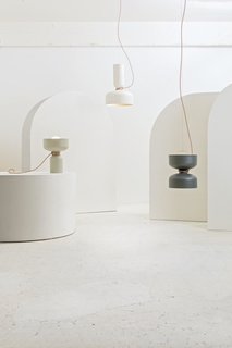 Spotlight Volumes — Design, Lukas Peet<br><br>A pendant light with two shades, made from a combination of four possible shade types. Each end has an LED globe bulb to illuminate both above and below. The electrical cord acts as an additional design feature, wrapping around the midsection and gently curving towards the ceiling. 