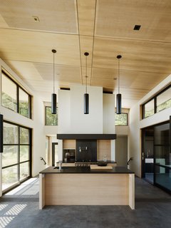 Warm wood and dark surfaces contrast with white walls.