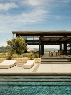The main living area opens up to a swimming pool and terrace, as well as another outdoor lounge with a fire pit and views of the town.