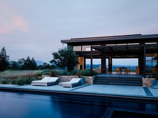50 Modern Homes With Floor-to-Ceiling Windows - Photo 20 of 50 - Comprised of two perpendicular bars atop a hill overlooking the village of Healdsburg, this home offers both ample social space ideal for entertaining and the privacy of a rural retreat. The taller section runs along the ridge of the hill and houses the home’s great room. Four oversized glass panels open dramatically on each side, transforming the space into an outdoor pavilion.