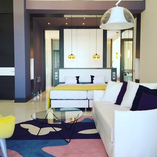 GM Architects’ linear construction and high ceilings are balanced by softer interior hues, abstract prints, and spherical pendant lamps that bring warmth and a sense of intimacy to the Opera Suite. 