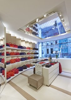 Lacing reminiscent of Longchamp’s LM motif appears across ceiling tiles, wall panels, and product display stands, tying the space together. 