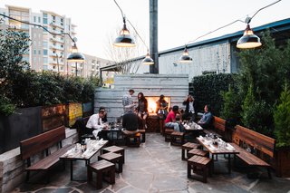 Diners who prefer to share a meal outdoors keep warm by the fireplace.