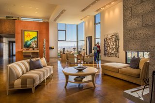 Recessed track lighting on the vaulted ceilings provide light and space in the spacious living area, and walls of glass afford the homeowner views of the Great Basin valley. The stained, polished concrete floors add a warm tone to the modern setting.