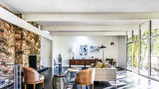A rock wall fireplace faces floor-to-ceiling glass panels that provide ventilation during the summer months. Fickett's signature ribbed ceilings accentuate the lines of the home. 