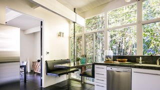 Booth seating in the eat-in kitchen creates a cozy nook behind a private bamboo fence.