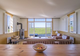 The open floor plan includes a kitchen with modern appliances, a half bath, and living and dining areas that open onto an outdoor terrace. A master bedroom and bunk room are upstairs along with a washer and dryer.