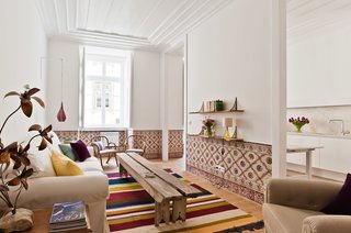 Baixa House Lets Travelers Be at Home in Lisbon - Photo 1 of 10 - Alorna, a one-bedroom apartment, faces the south and enjoys plenty of light. The 19th-century tiles were removed and carefully cleaned before being reinstalled; they also provided the color inspiration for the Mizette Nielsen rug.