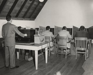 This Book Unearths a Midcentury Personality Study on Architectural Giants - Photo 4 of 13 - Researchers simulate the Conformity Test. In this scenario, five subjects in private booths estimate distances after a light indicates the other participants' answers—the supplied answers are fake, however, allowing this test to measure the effect of peer pressure on judgment. While Victor Lundy saw through the deception, others deferred to the false responses. 