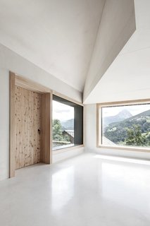 Find Sanctuary in This Chalet in the Italian Alps - Photo 4 of 12 - In contrast to the dark exterior, the interior is made of white concrete with aggregates of dolomite rock.