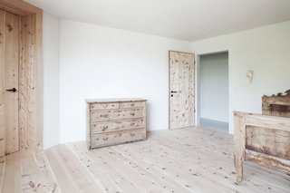 Find Sanctuary in This Chalet in the Italian Alps - Photo 10 of 12 - Two bedrooms occupy the second floor. This one, outfitted with stone pine furniture, looks out at a steep meadow.