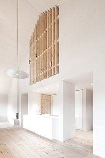 Find Sanctuary in This Chalet in the Italian Alps - Photo 7 of 12 - Upstairs, a wooden slatted wall doubles as a bookshelf.