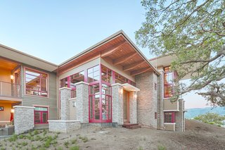 The home rises and falls across 7 levels to accommodate the contours of the site. While the exterior dry stacked stone, cedar siding, and wood trim echo the natural landscape, the red windows lend contrast and definition to the structure.