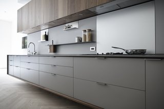 In a Henrybuilt kitchen system, every detail helps orchestrate a streamlined experience. For example, the pulls above protrude to match the plane of the counter and end panels. Drain fields are milled onto work surfaces to fit custom cutting boards and colanders, and low energy LED lights are morticed into the bottom of wall units, which have scoops instead of handles. 
