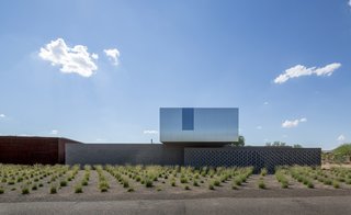 Clad in stainless steel and coated glass, the upstairs volume seems to hover over the thick masonry walls and change colors with the shifting sky.