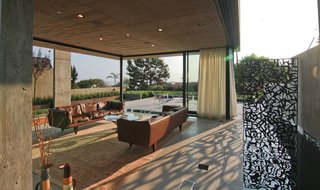 Multi-Slide Doors by Western Window Systems retract and allow the living room to enjoy the offshore breeze. The pool extends along one side, allowing the homeowners to feel as though they are floating over water.