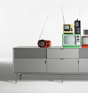 The perforated steel door of the Dang 2 Door / 2 Drawer Console accommodates remote controls while maintaining a clean aesthetic.