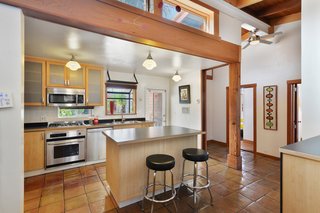 Apart from the side-by-side bathrooms, the layout of the home doesn't reflect its commercial beginnings. The kitchen, which features Saltillo tile flooring, used to be a back office. 