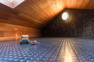 The couple’s children had requested a treehouse, but the lack of old growth trees on the property prompted Wendi and Lukas to include a loft above the renovated garage. The hatch skylights allow the boys to have a lookout over the backyard, and the chalkboard wall is great for doodling.