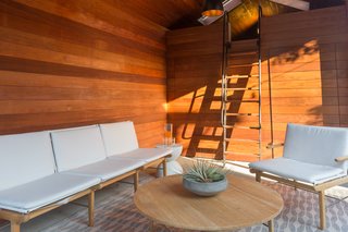 Pivot doors to the storage area are disguised by redwood siding.