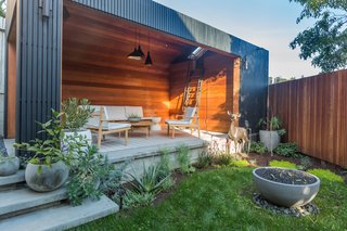 The minimalist garage takes the form of an archetypal house. The gutters and weather- and waterproofing are concealed by redwood slats that can be removed for future repairs. Black Pine Tar coats the rainscreen, creating a striking contrast to the warm interior.