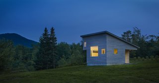 Built to stay cozy through all kinds of weather, Micro House has a gray-stained, cedar rain screen in addition to Lo-E glass. At a diagonal from the front porch, another subtracted corner makes space for a sleeping loft.