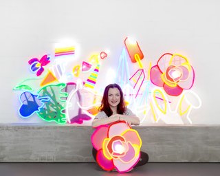Natalie Jarvis poses with her creations. When she initially conceived of Electric Confetti, she had considered using traditional neon, but its fragility and the presence of mercury drove her to research other alternatives—leading to her discovery of LED neon flex.
