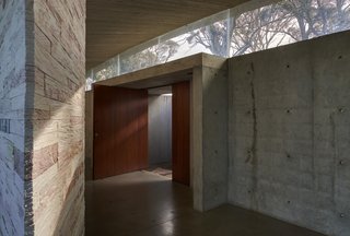 An Internationally Celebrated Home in the Australian Backcountry Asks $9M - Photo 2 of 13 - The entrance gallery provides a meditative sense of arrival and a counterpoint to the rest of the house, which is exposed on three sides. The Mudgee tiger skin stack stone wall was created over hundreds of hours by the project's dedicated builder and hand-crafter.