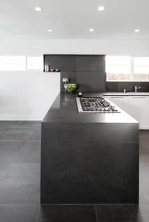 A Bosch 36" Gas Cooktop and 36" Downdraft Ventilation are integrated into the counter, allowing the space to feel open and unobstructed by a stove hood.