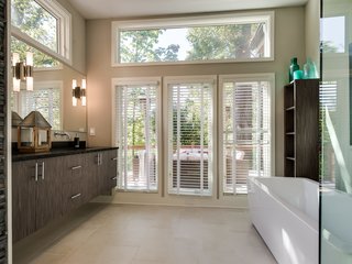 A frosted glass pocket door leads to the master bathroom, which enjoys a large free-standing tub and a floating double vanity. 