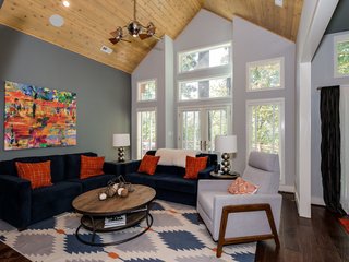 On the other side of the fireplace is the great room, where a vaulted cedar ceiling, measuring 18 feet at its height, adds to the feeling of spaciousness. The French doors lead to the balcony. 