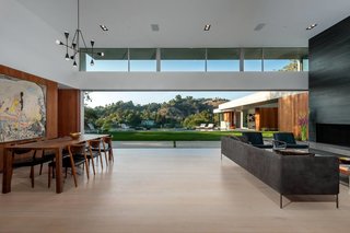 The open plan living and dining areas benefit from a long clerestory window, while sliding doors by Metal Window Corporation blur the boundary between interior and exterior.
