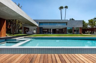 An extended wood terrace surrounds the pool, creating a courtyard setting.