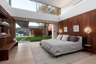 The master bedroom also has seamless outdoor access. The covered breezeway leads to the guest house, comprised of its own living space, kitchen, and bedroom, currently being used as an office.