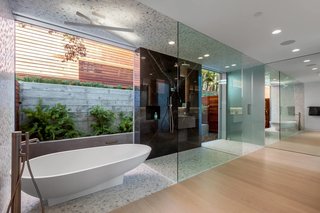 An Agape Spoon bathtub by Benedini Associati provides a sculptural focus in the master bathroom, which has sliding glass doors that open to a private garden area. 