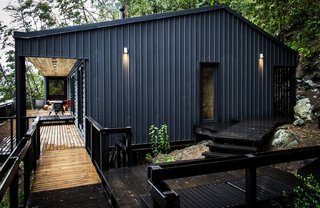 Modular corrugated steel protects the house against year-round rain. Home automation company Home Control outfitted the residence with energy-efficient LED lights and zone-specific audio systems.