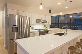 The kitchen boasts white quartz countertops and stainless steel appliances.