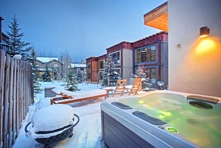 The lower deck holds a fire pit and hot tub, perfect for outdoor entertaining despite the cold. 