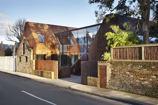 "Kew House was conceived as an interplay between the rustic exterior of weathering steel and retained stable wall and the refined, light interior," says Piercy, "the glazed circulation link revealing the contrast from inside and out." 
