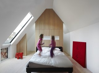 Large windows, partially screened by perforated steel, make for an airy master bedroom, which exhibits more bespoke oak cabinetry.