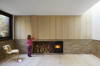 Bespoke oak cabinetry, produced by an on-site joinery workshop, conceals storage in the living room. A curved ceiling softens the space.
