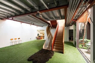 Alternative routes, levels, and spaces create a landscape of delight in the home—like this slide that leads from the living room to the basement.