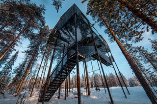 Designed by the renowned firm Snøhetta, the structure hovers 10 meters above the ground with a black-and-white print of the canopy covering the bottom façade, creating a trompe l'oeil effect. The two bedrooms, bathroom, lounge area, and netted terrace are arranged across two slightly different levels, accommodating up to five guests.