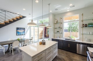 Rios describes Unit B as the more feminine of the two units. Here, black and white cabinets feature a glint of brass hardware. Made of brass galvanized pipe and glass, the shelves by the kitchen sink combine aesthetics and function.