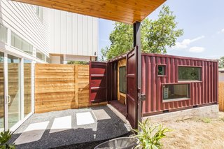The two units in the duplex share a wall in the main house, so Rios continued the mirrored effect by placing the shipping containers side by side about 10 feet away from the home. Cut into the sides, the windows allow natural light to illuminate the shipping container and are designed to give parents a view of the kids playing in the backyard. 