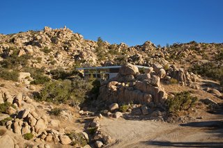 Offered at $674K, This Hybrid Prefab Is in Tune With the Californian Desert - Photo 1 of 7 - Despite the remoteness of the lot and the challenges it posed, the light-gauge steel frame was erected in days, and the entire home was completed in two months—a testament to the ease and efficiency of the prefabricated system. The building sits on upright columns that are bolted to independent concrete footings, giving the home the illusion of floating.