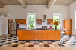 Reed designed the custom cabinets, which are made of lacewood and frosted glass. The kitchen also features a Bosch dishwasher and range hood, KitchenAid stove, and GE Profile refrigerator.