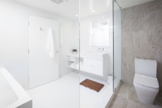 "We kept to a very simple and streamlined palette and carefully selected light fixtures that echoed the lines and movement within the space," says Misra. The monochromatic bathroom features a custom white lacquer vanity and Porcelanosa tiles. 