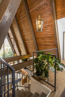 Upon entering, the foyer offers dramatic views of the San Gabriel Mountains straight ahead, framed by the wooden beams of the steeply pitched roof. On either side of the foyer are the master suite and second bedroom.