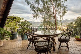 The semi-sheltered terrace allows for outdoor dining with views of the surrounding neighborhood and nearby mountains.